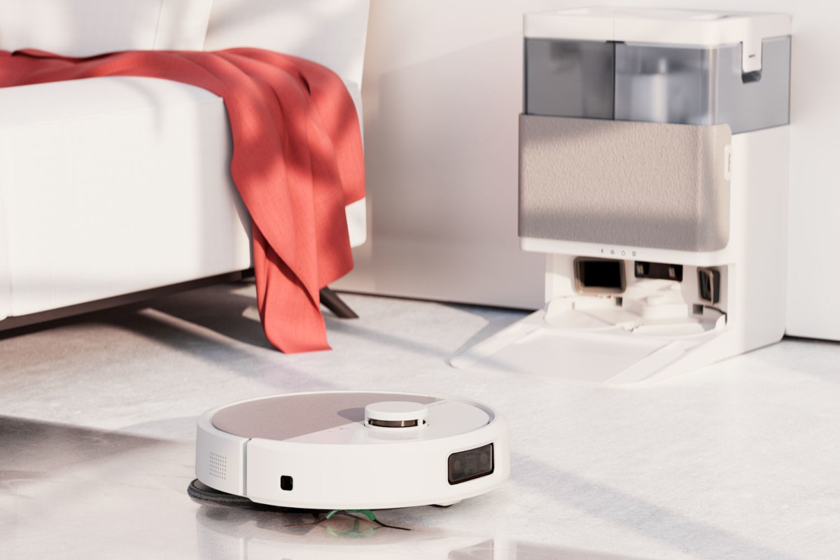 Biała Roomba 505 wjeżdża pod kanapę w salonie