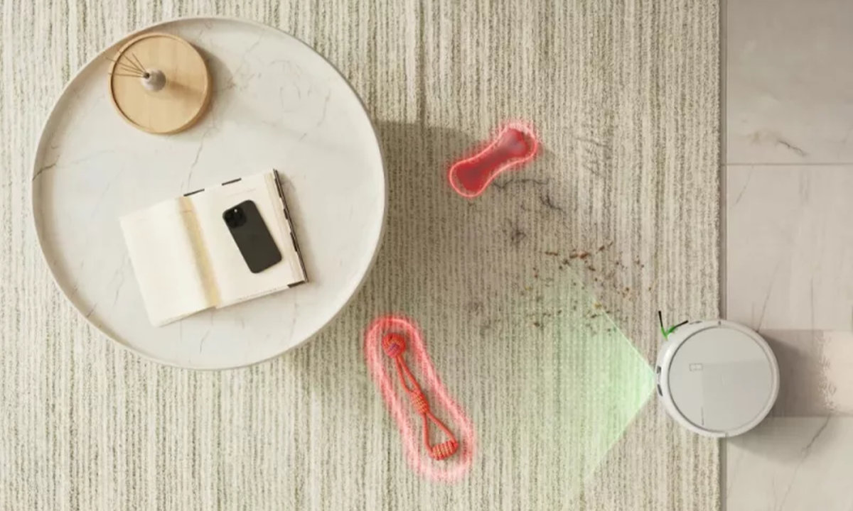 Roomba Plus 575 Combo rozpoznaje i omija psie zabawki na dywanie w salonie z sofą i stolikiem kawowym