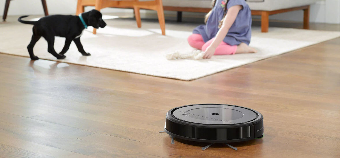Dziewczynka bawi się z psem a robot roomba combo sprząta podłogę