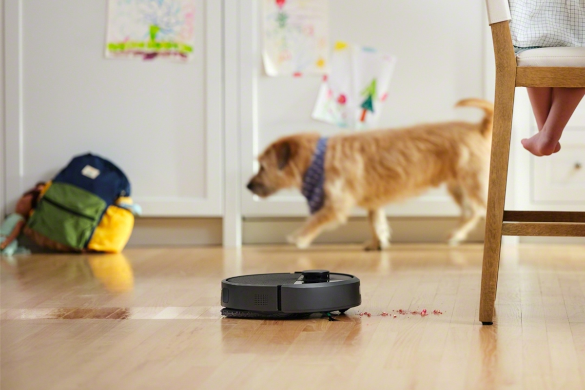 Roomba 405 zmywa podłogę w kuchni, w tle pies
