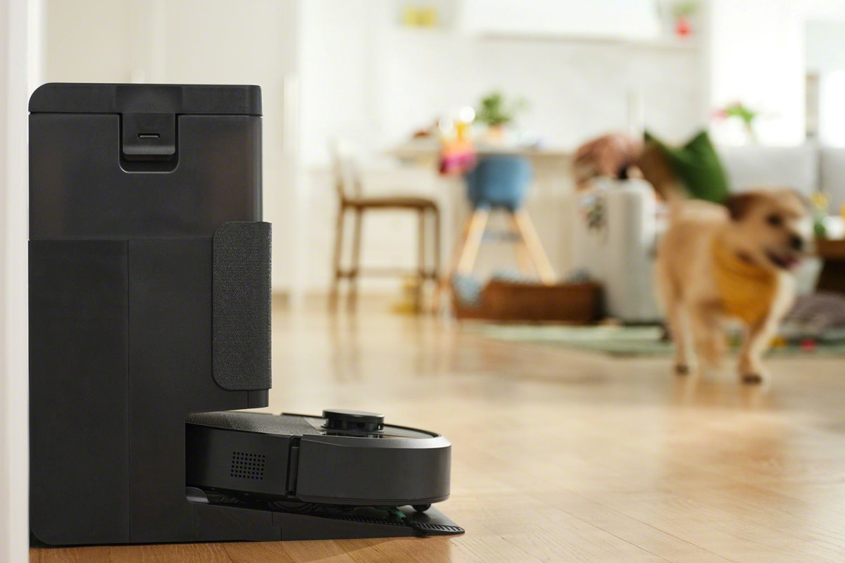 Roomba 405 sprząta ze stacjądokującą, w tle pies