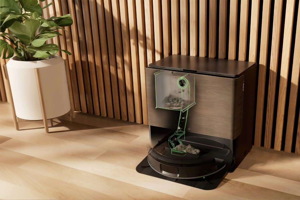 Robot Roomba Max 705 Combo stoi w stacji AutoWash w salonie obok rośliny doniczkowej