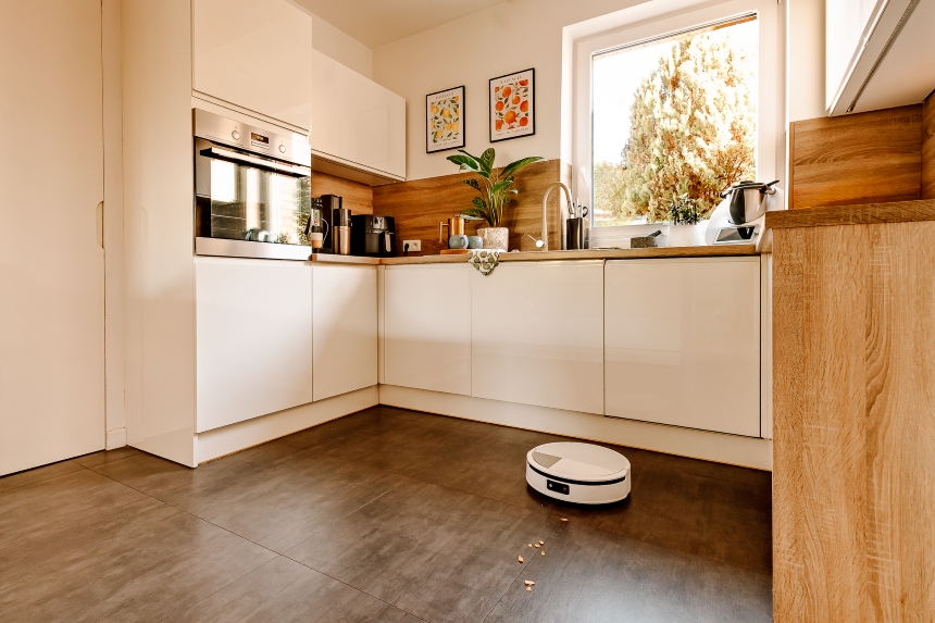Robot Roomba Max 705 Combo sprząta płytki w nowoczesnej kuchni, na blacie widoczne różne sprzęty i przybory kuchenne