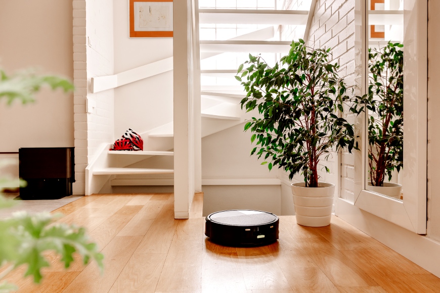 Robot Roomba Max 705 Combo odkurza przedpokój w domu jednorodzinnym, na drugim planie widoczna stacja AutoWash i schody