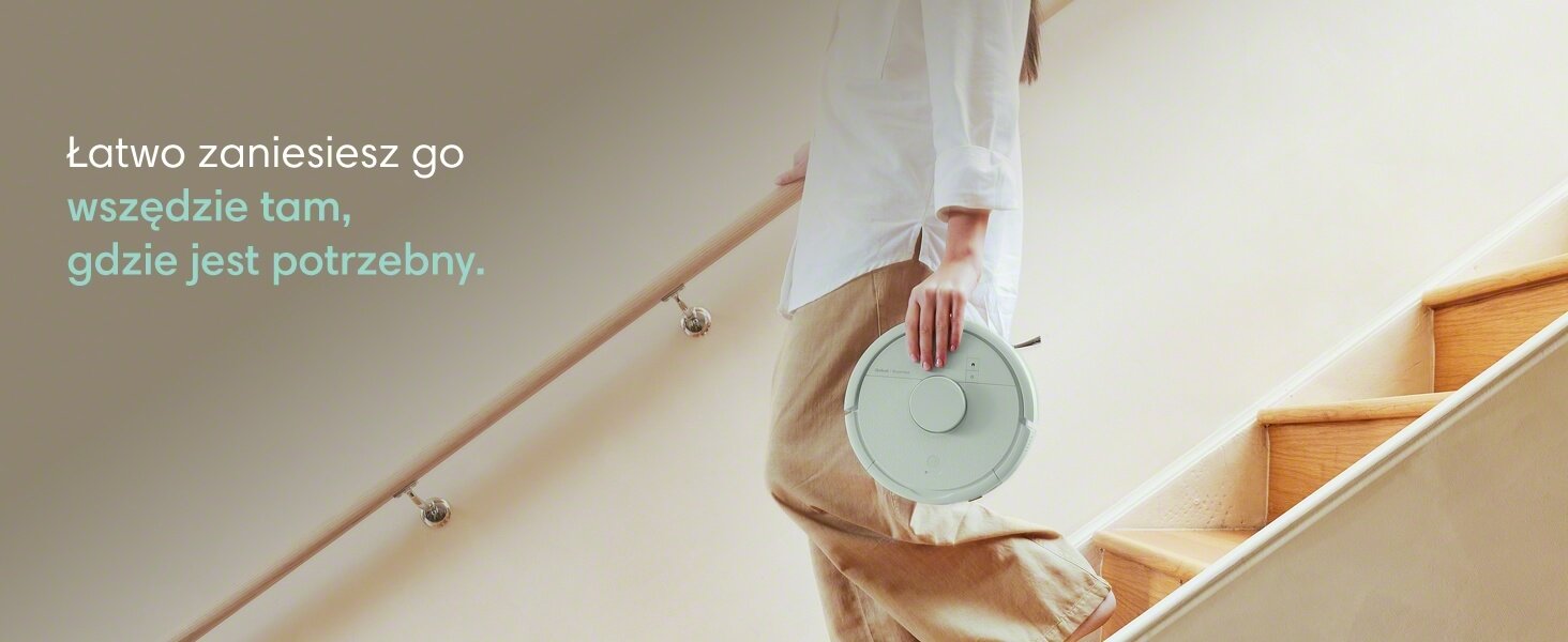 Kobieta niesie robota Roomba Mini Combo schodząc po schodach