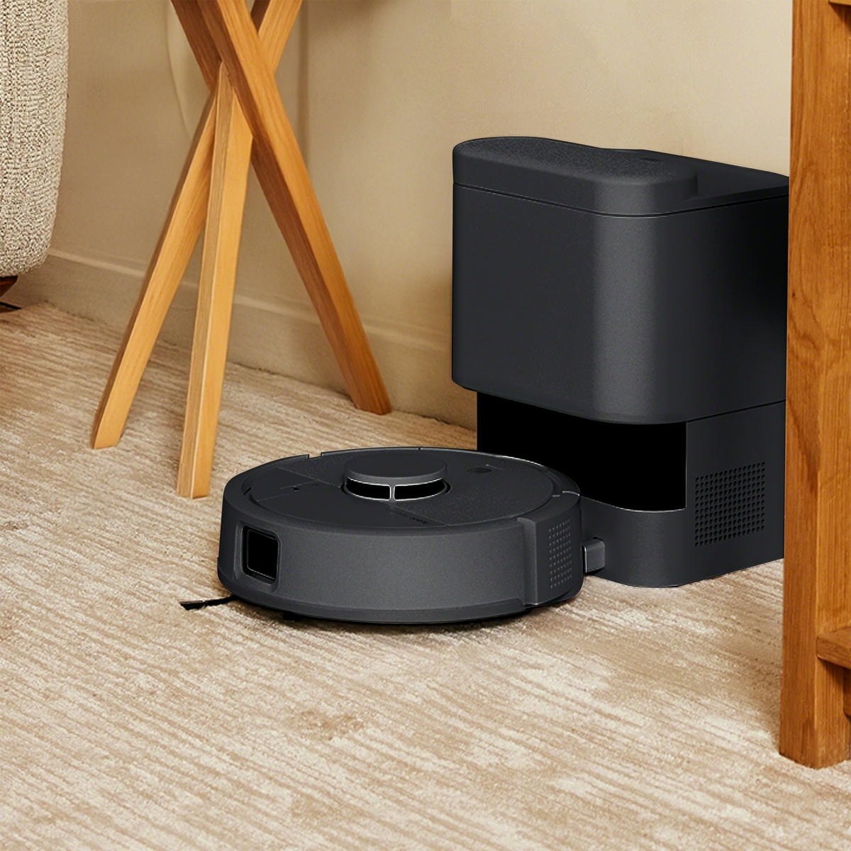 Roomba Mini Combo ładuje akumulator w stacji dokującej AutoEmpty stojąc w ciasnym kącie mieszkania