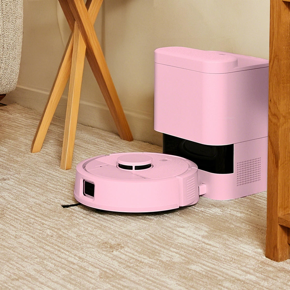 Roomba Mini Combo ładuje akumulator w stacji dokującej AutoEmpty stojąc w ciasnym kącie mieszkania