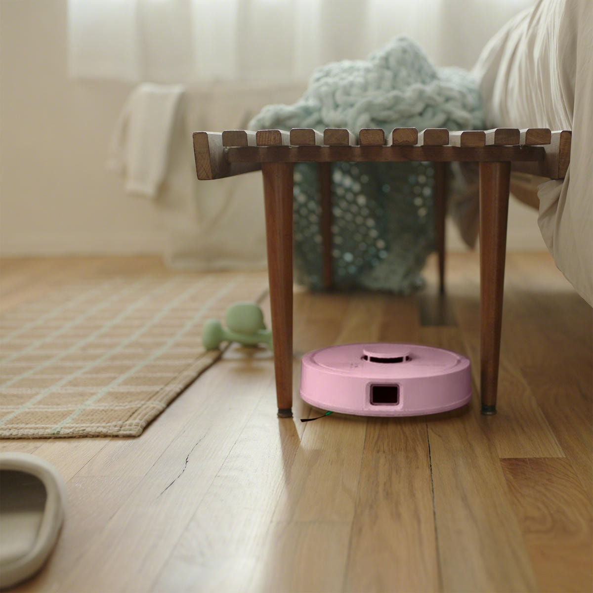 Robot Roomba Mini przejeżdża między nogami stołka w salonie