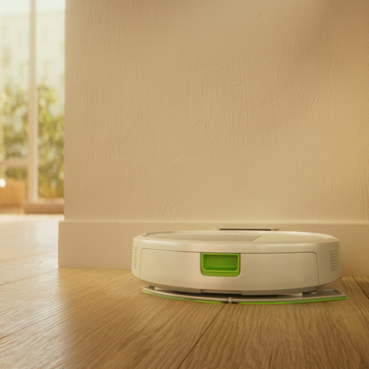 Roomba 115 Combo ładuje się w&nbsp;stacji dokującej na twardej podłodze w&nbsp;przedpokoju