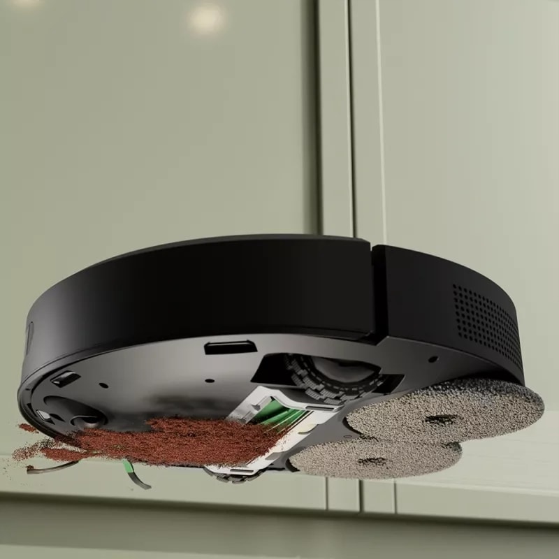 Widok spod robota pokazujący jednoczesne odkurzanie rozsypanej kawy