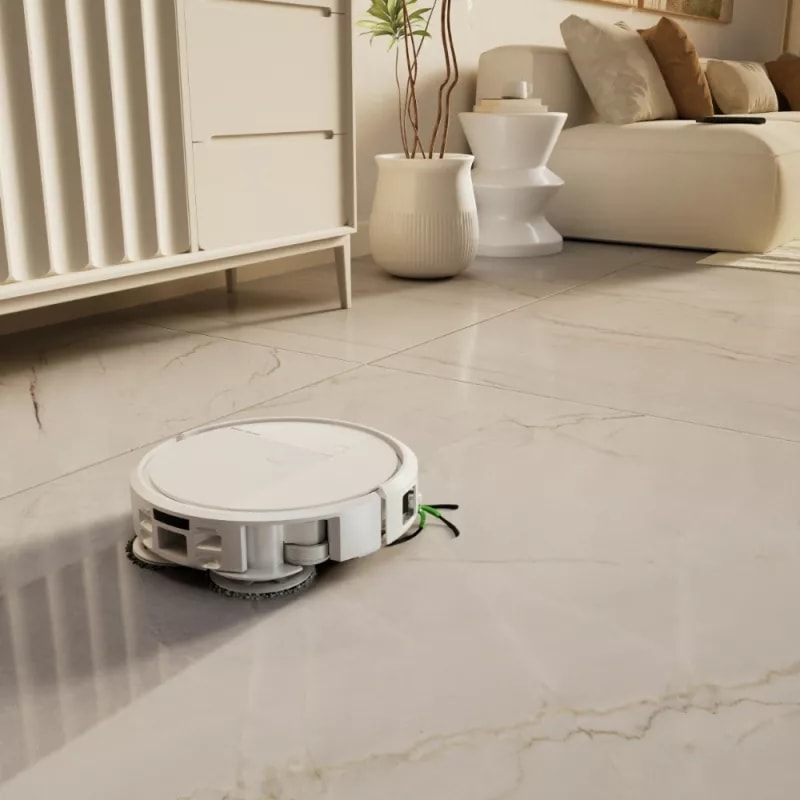 Roomba 575 Combo mopuje gres w salonie jadąc obok komody w kierunku sofy