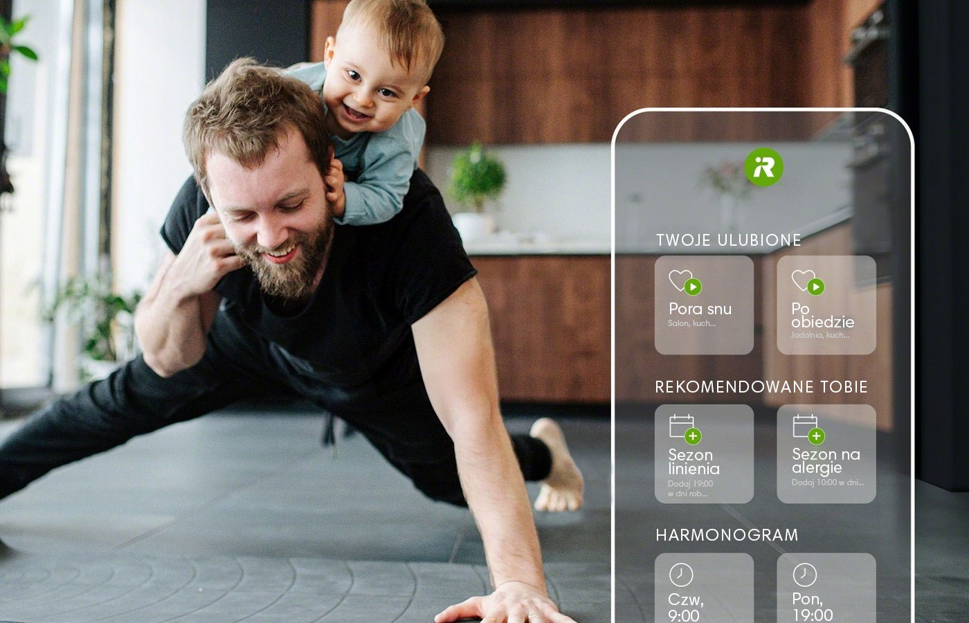 Mężczyzna z dzieckiem na barkach ćwiczy pompki w domowym zaciszu. Na zdjęciu ekran smartfona pokazuje możliwości nowej aplikacji iRobot Home.